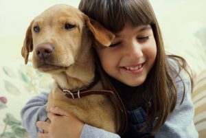 portrait of young girl hugging her dog